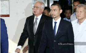 Former prime minister Datuk Seri Najib Razak (left) arriving with books in hand at the High Court in Kuala Lumpur yesterday. Pix by NSTP/Eizairi Shamsudin